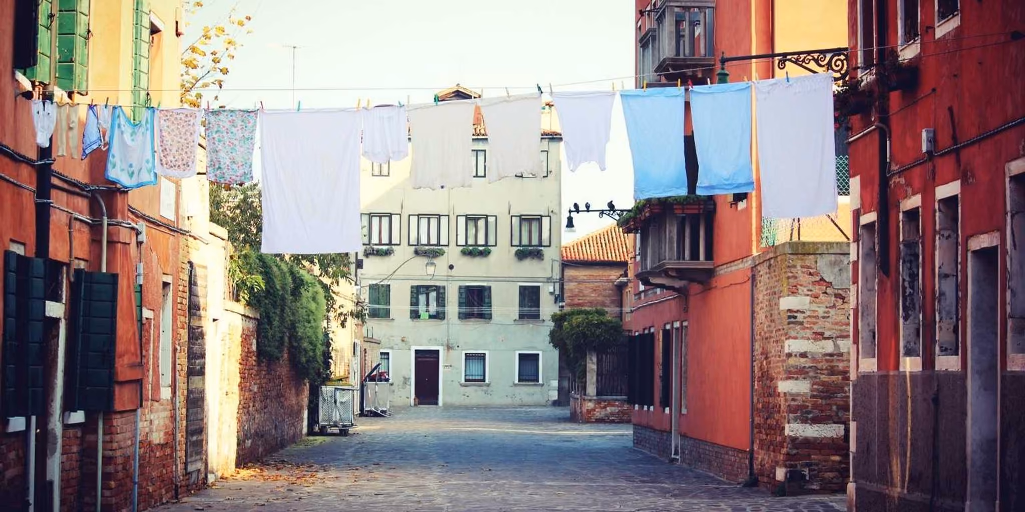 Rua de um bairro antigo com roupa estendida entre as fachadas